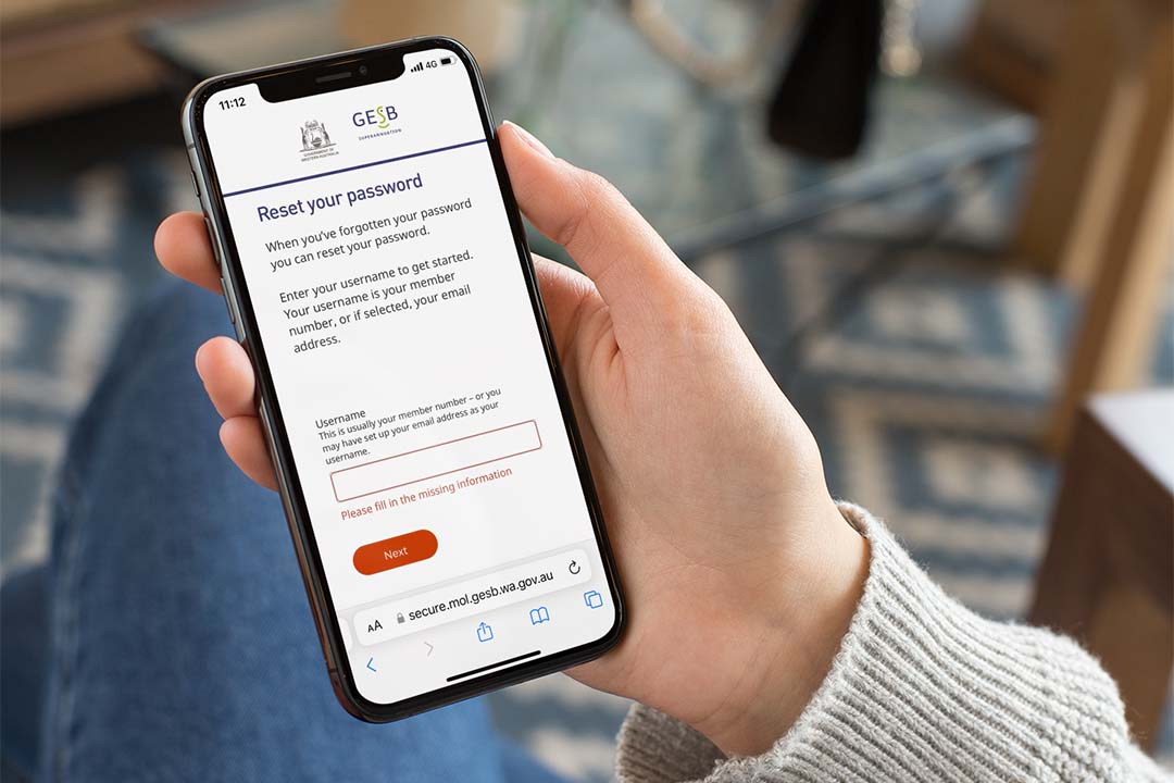 An iPhone being held by a woman showing a login screen 