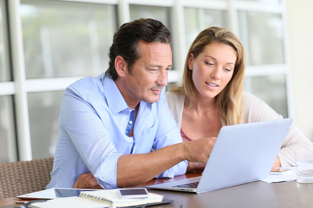 Couple with laptop at table (Man with blue collared shirt)