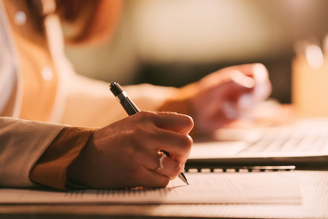 Woman with ring writing on paper