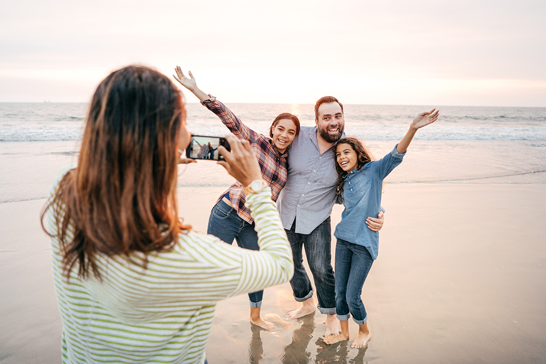 Family taking photos at the beach