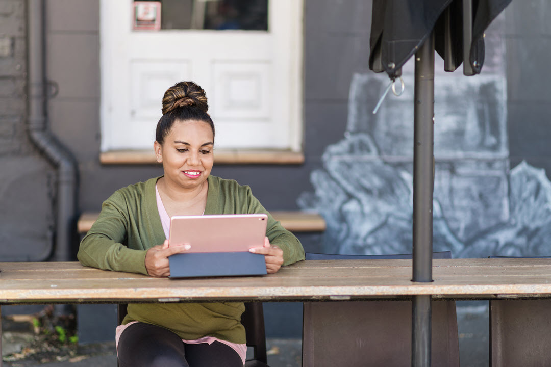 Woman using pink tablet outside