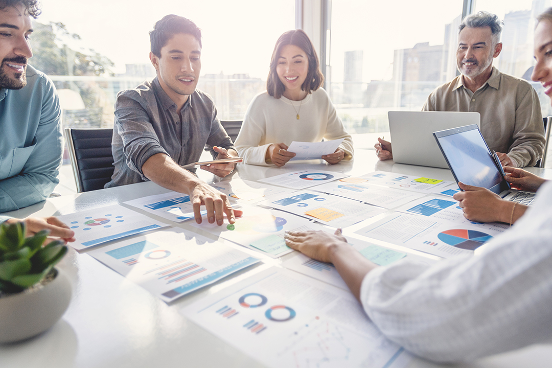 6 colleagues discussing investments at a large office table