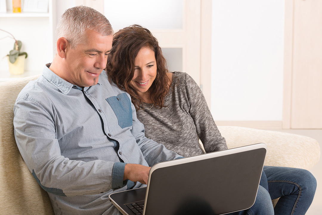 Couple sitting on couch with laptop